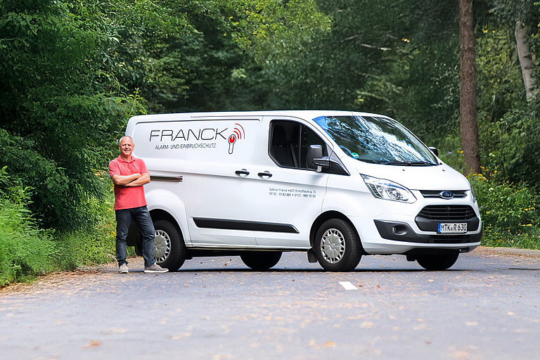 Gabriel Franck vor seinem Firmenwagen von Franck Alarm- und Einbruchschutz 