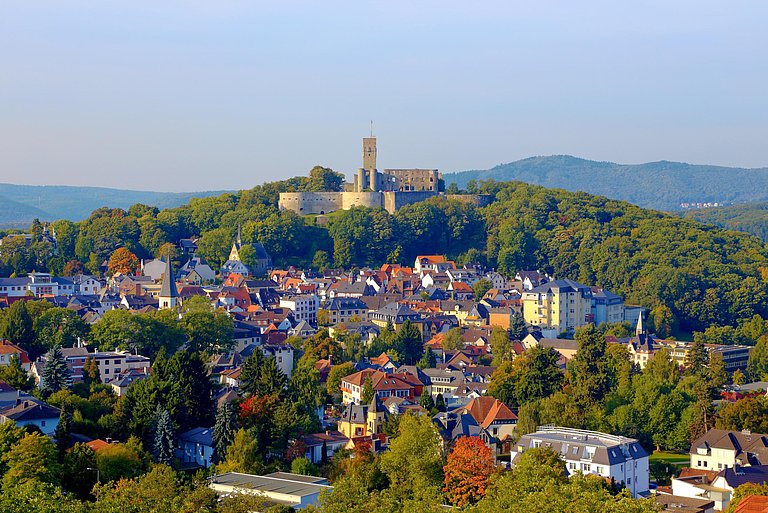 Burg auf einem Berg. Im Vordergrund die Ortschaft Königstein